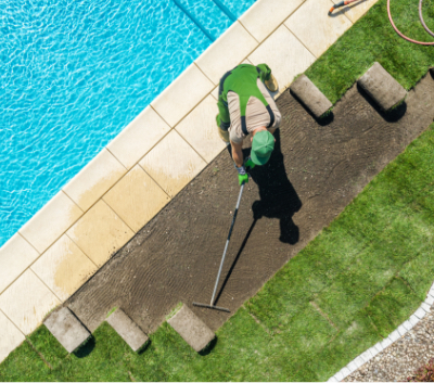 Lawn Mowing Sunshine Coast - man laying grass next to pool